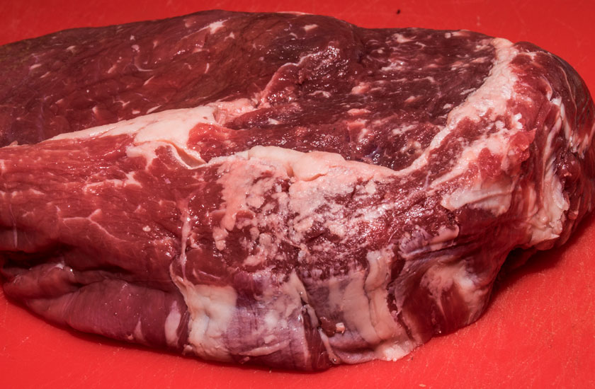 Uncooked ribeye of beef. Beautifully marbled.