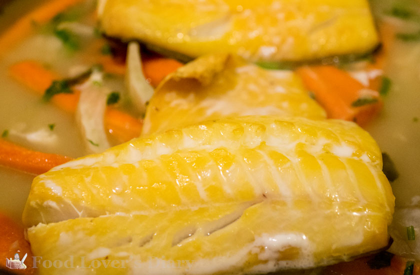 Haddock steaming over the stock and carrots