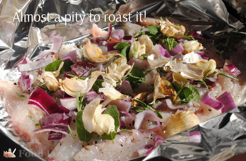 Fish laid out on foil and covered with the garlic and herbs - very pretty